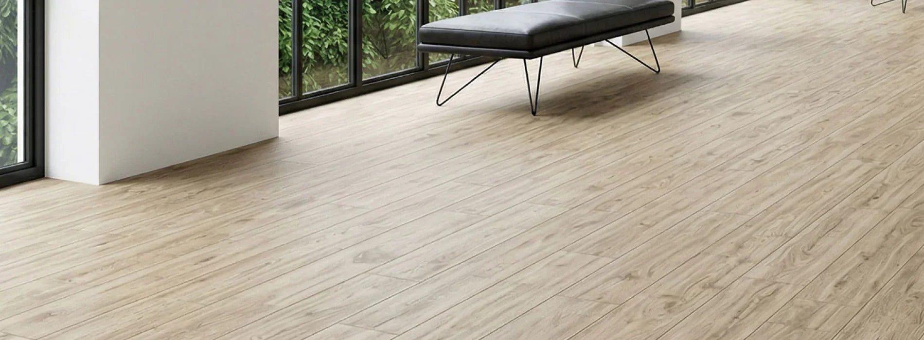 Light wood grain luxury vinyl plank flooring in modern room with black bench and large windows